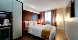 a hotel room with a bed and a television at Design Hotel f6 in Geneva