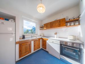 a kitchen with wooden cabinets and a sink and a window at Villa Suredl in Ortisei