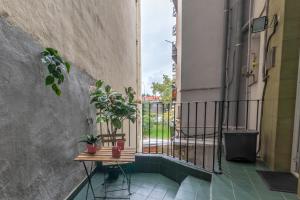 a balcony with a table and potted plants on it at INAR céntrico apartamento junto Ayuntamiento & Ría in Bilbao