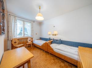 a room with two beds and a table in it at Villa Suredl in Ortisei