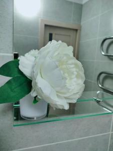 a white flower in a vase on a counter at Квартира на Панфилова "Арбат" 1 комн in Almaty