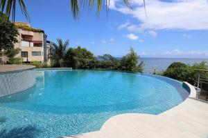 a large blue swimming pool in front of a building at City Lodge Appartment in Te Auae