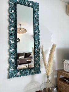 City Lodge Appartment في Te Auae: مرآة على جدار مع أريكة في غرفة المعيشة