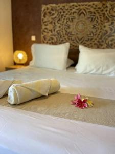 City Lodge Appartment في Te Auae: منشفة مطوية على سرير مع وردة عليه
