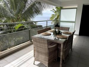una mesa en un balcón con vistas al océano en City Lodge Appartment, en Te Auae