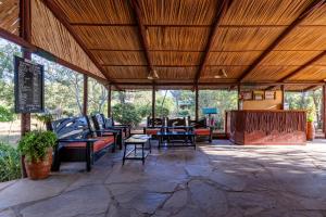 een paviljoen met banken en tafels op een patio bij Sentrim Tsavo Lodge in Tsavo