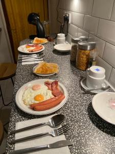 a table topped with plates of breakfast foods and utensils at CHARLES INN in Liverpool