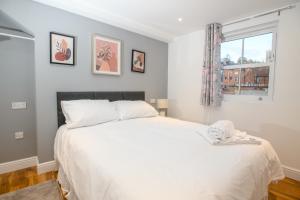 a bedroom with a large white bed and a window at Cathedral View Rooms in Lincoln