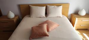a bedroom with a bed with two pillows on it at Casa Das Conchas in Costa da Caparica