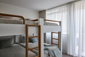 1 Schlafzimmer mit 2 Etagenbetten und einem Fenster in der Unterkunft Casa Tamarama in Sydney