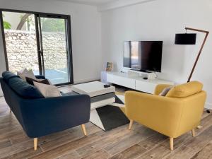 a living room with two chairs and a television at Le Clos Guiton in La Rochelle