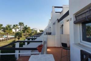 a balcony with tables and chairs on a building at Condado de alhama, naranjos 8 in Alhama de Murcia