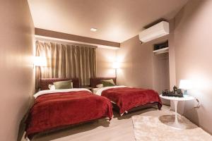 Habitación de hotel con 2 camas con colchas rojas en RESIDENCE HARIMAYA-Vacation STAY 99863v en Kochi