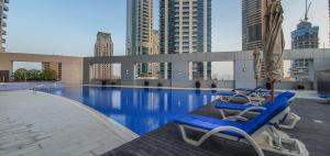 basen z 2 leżakami i parasolem w obiekcie Cute Dubai Marina Studio in Skyview Tower w Dubaju