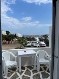 a balcony with a table and two chairs and a window at Panagiotis Rooms in Naousa