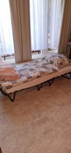 a bed sitting in a room with windows at Ferienwohnung Fellnasen WG in Krefeld
