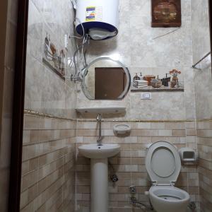 ein Badezimmer mit einem WC, einem Waschbecken und einem Spiegel in der Unterkunft Nana Pyramids Guest House in Kairo