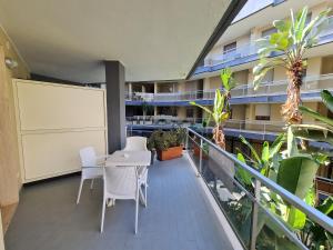 an apartment balcony with a white table and chairs at Monti Guest House Alghero in Alghero