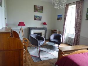 a living room with two chairs and a fireplace at chateau de Craon in Comblessac