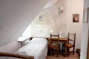 a bedroom with a bed and a desk and a table at Karczówka Klasztor in Kielce
