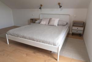 ein weißes Bett mit rosa Kissen im Schlafzimmer in der Unterkunft Deja View 