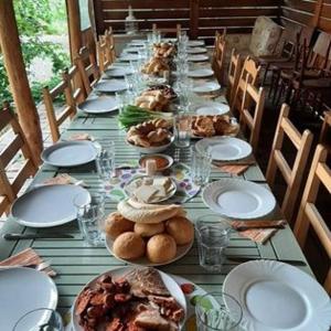uma mesa longa com pratos de comida em Élő Tisza Vendégház em Nagykörů