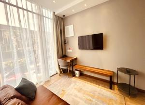 sala de estar con TV de pantalla plana en la pared en oxy suites 1-01B at Shop House Meisterstadt Pollux Habibie, en Batam Centre