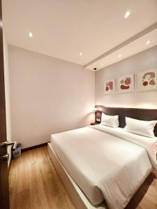 1 dormitorio con 1 cama grande con sábanas blancas en oxy suites 1-01B at Shop House Meisterstadt Pollux Habibie en Batam Centre