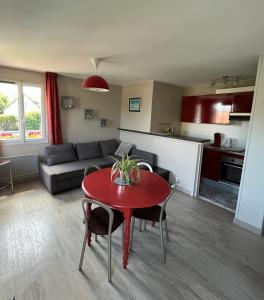 - un salon avec une table rouge et un canapé dans l'établissement Hotel la piscine, à Villers-sur-Mer