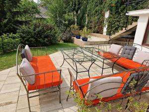 a patio with two chairs and a table with orange cushions at Spirii house in Braşov