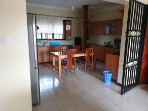 a kitchen and dining room with a table and chairs at 3-Bedroom Mbarara Apartment with Optional Farm Tour in Mbarara