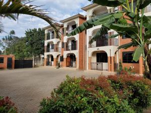 a large building with a courtyard in front of it at 3-Bedroom Mbarara Apartment with Optional Farm Tour in Mbarara