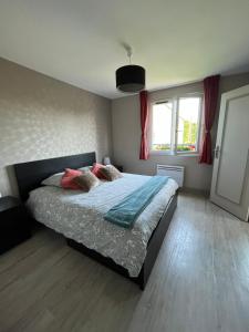 een slaapkamer met een bed met kussens erop bij Hotel la piscine in Villers-sur-Mer