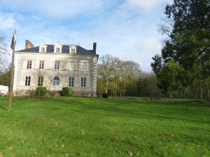 a large white house with a grassy field in front at chateau de Craon in Comblessac