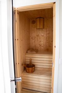 a wooden sauna with a wooden bucket in it at Your own 30sqm house with kitchen, sauna and loft. in Malmö
