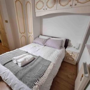 een kleine slaapkamer met een wit bed en een telefoon bij cosy one bed Mill hill in Hendon