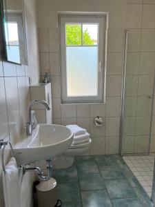 a bathroom with a sink and a toilet and a window at Ferienwohnung Schleistübchen in Fahrdorf