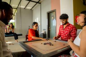 a group of people standing around a table playing a game at The Hosteller Gokarna in Gokarna