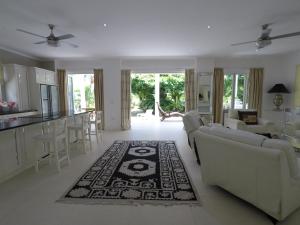 a living room with couches and a kitchen and a table at Las Brisas Villa - Chateau Elysium in Beau Vallon