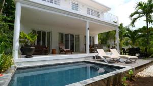 a house with a swimming pool in front of a house at Las Brisas Villa - Chateau Elysium in Beau Vallon +15 photos