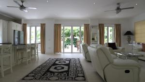a living room with white furniture and a kitchen at Las Brisas Villa - Chateau Elysium in Beau Vallon