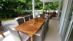 a wooden table and chairs on a patio at Las Brisas Villa - Chateau Elysium in Beau Vallon