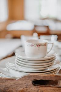 una pila de platos y una taza de café sobre una mesa en Zum Riesen Historic Refugium en Laces