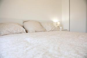 a bedroom with a white bed with two pillows at Le Saint Cyrien in Saint-Cyr-lʼÉcole
