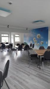 une chambre avec des tables et des chaises et un tableau mural dans l'établissement DEULA Witzenhausen GmbH, à Witzenhausen
