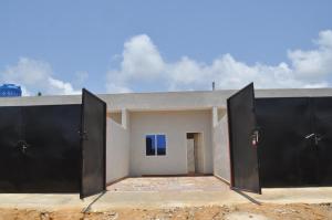 a house with two black doors in front of it at Motel Ayélawadjè Palm Beach in Ekpé