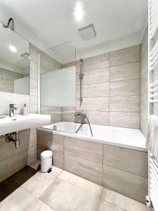 een badkamer met een bad en een wastafel bij Apartment Schönbrunn in Wenen