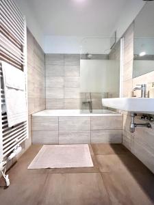 een witte badkamer met een bad en een wastafel bij Apartment Schönbrunn in Wenen