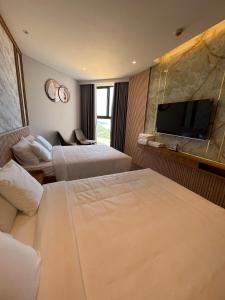 潘切的住宿－Apec View biển - Mũi Né，酒店客房设有两张床和一台平面电视。