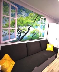 sala de estar con sofá frente a 2 ventanas en Chillout Apart 4You, en Świeradów-Zdrój